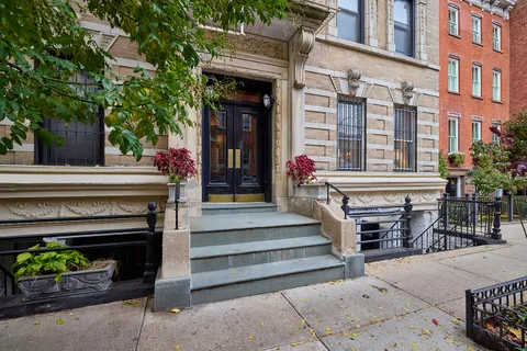 a front view of a building with outdoor seating and plants