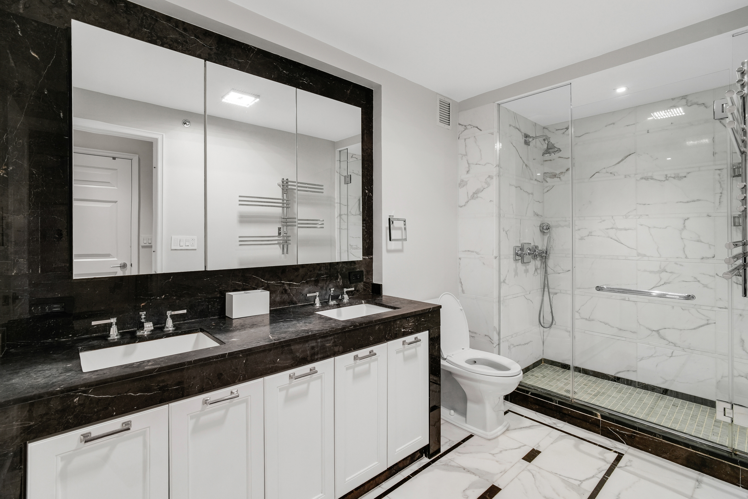 205 East 85th Street, Unit 16H Manhattan, NY 10028 - Photo 6 of 14 a bathroom with a granite countertop sink a toilet a mirror and shower
