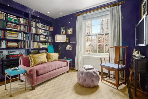 a living room with furniture and a bookshelf