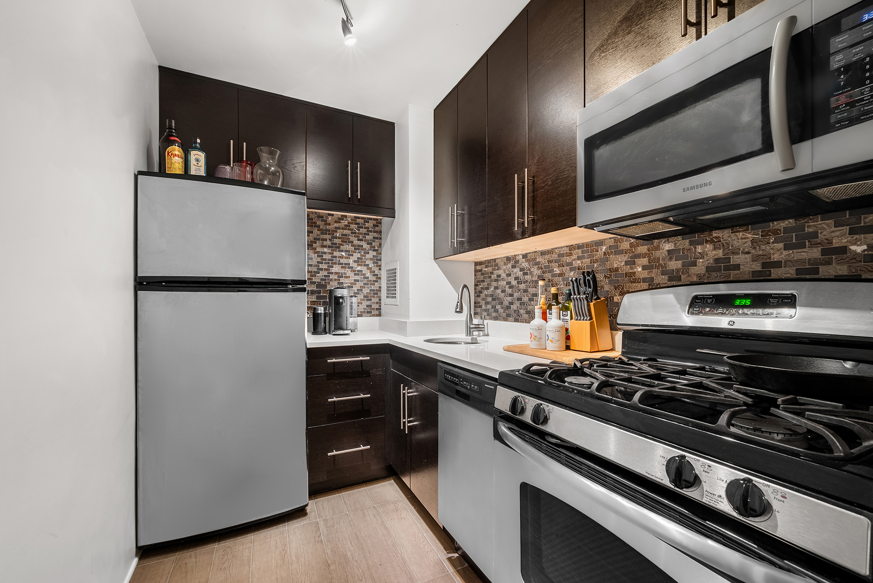 16 West 16th Street, Unit 3FS Manhattan, NY 10011 - Photo 4 of 12 a kitchen with stainless steel appliances granite countertop a stove and a refrigerator