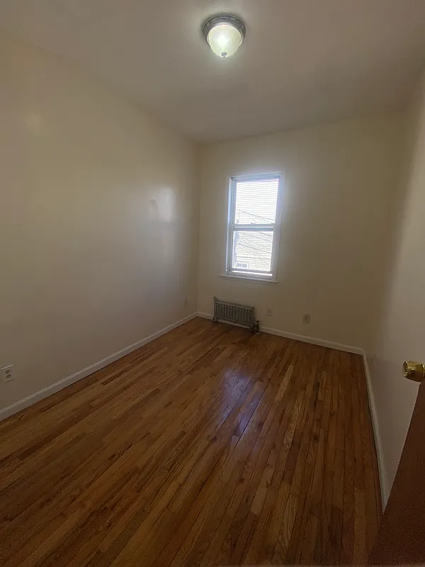 1251 Saint Marks Avenue, Unit 2 Brooklyn, NY 11213 - Photo 3 of 5 an empty room with wooden floor and windows