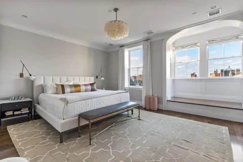 a bed sitting in a bedroom next to a window