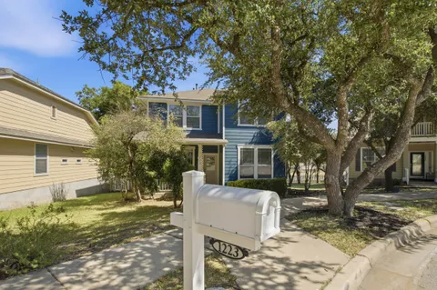 a view of a house with a tree in the yard