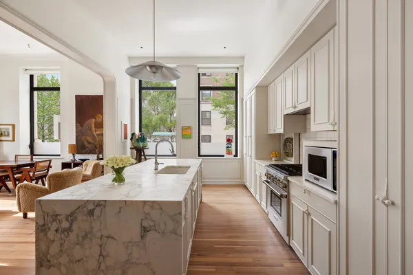 a large kitchen with kitchen island granite countertop a large counter top appliances a sink and living room view
