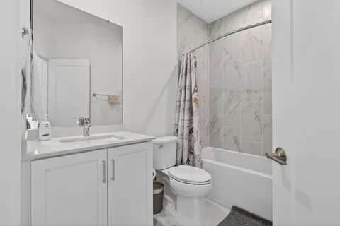 a bathroom with a granite countertop sink toilet and shower