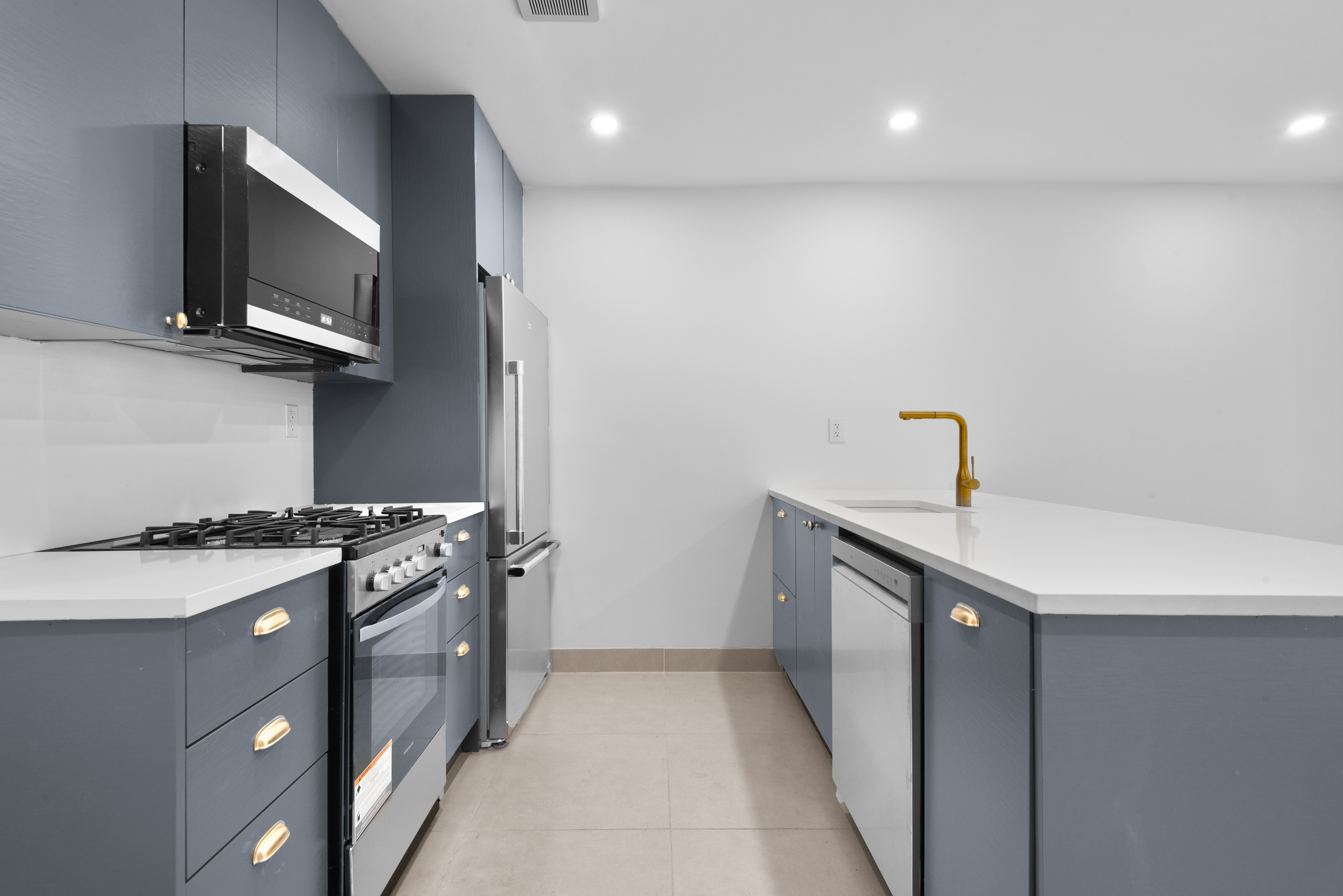 30 Weirfield Street Brooklyn, NY 11221 - Photo 25 of 29 a kitchen with stainless steel appliances a sink dishwasher a stove and a microwave oven with cabinets