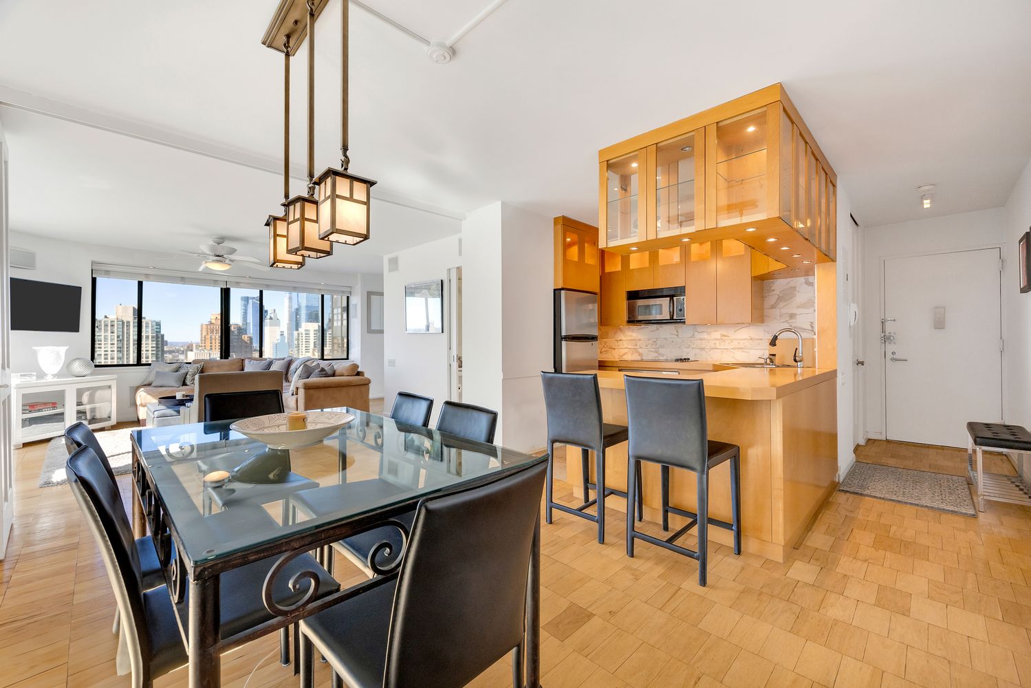a view of a dining room and livingroom with furniture wooden floor a chandelier
