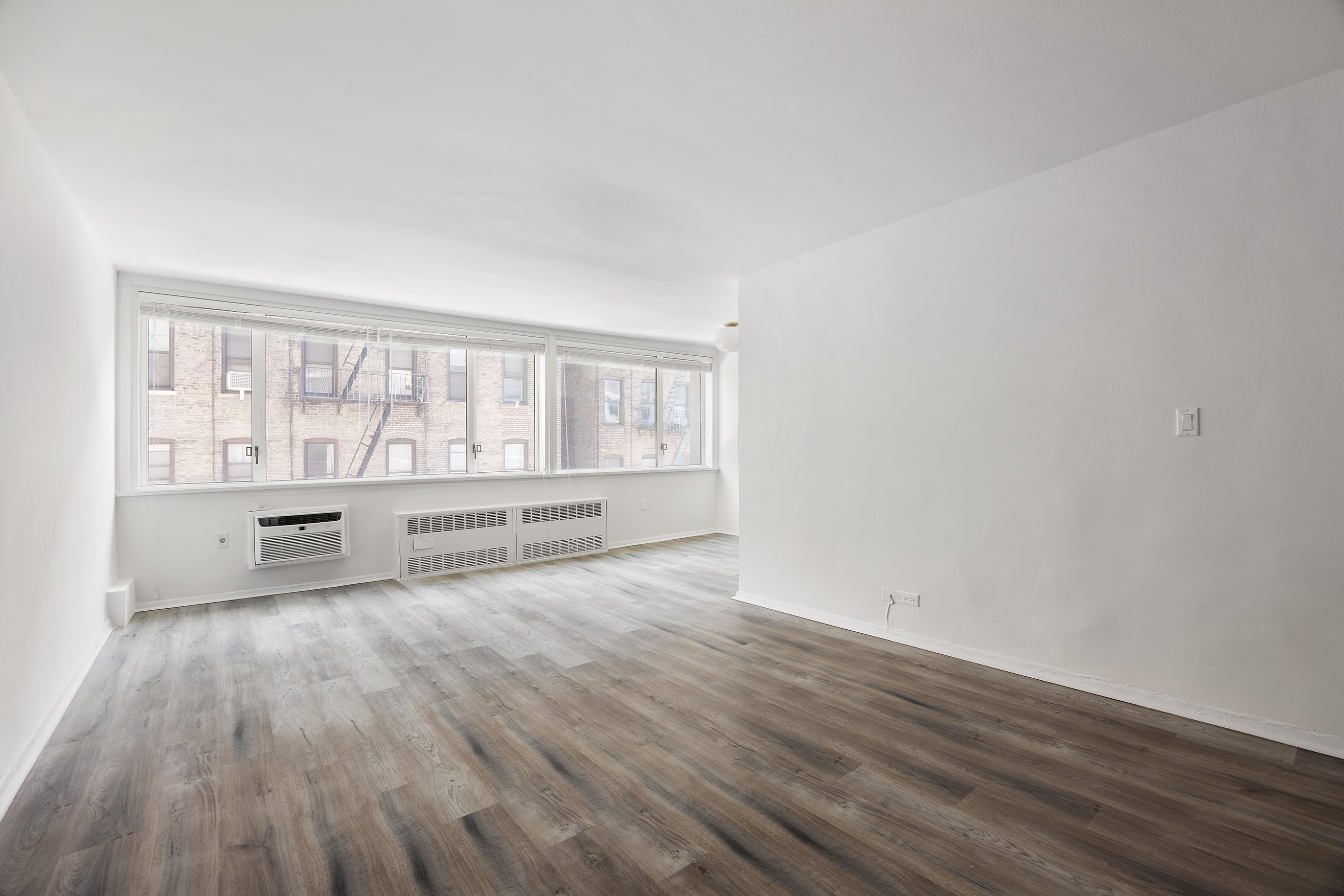 333 East 14th Street, Unit 4N Manhattan, NY 10003 - Photo 4 of 13 wooden floor in an empty room with a window