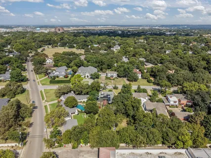 an aerial view of residential houses with outdoor space and trees