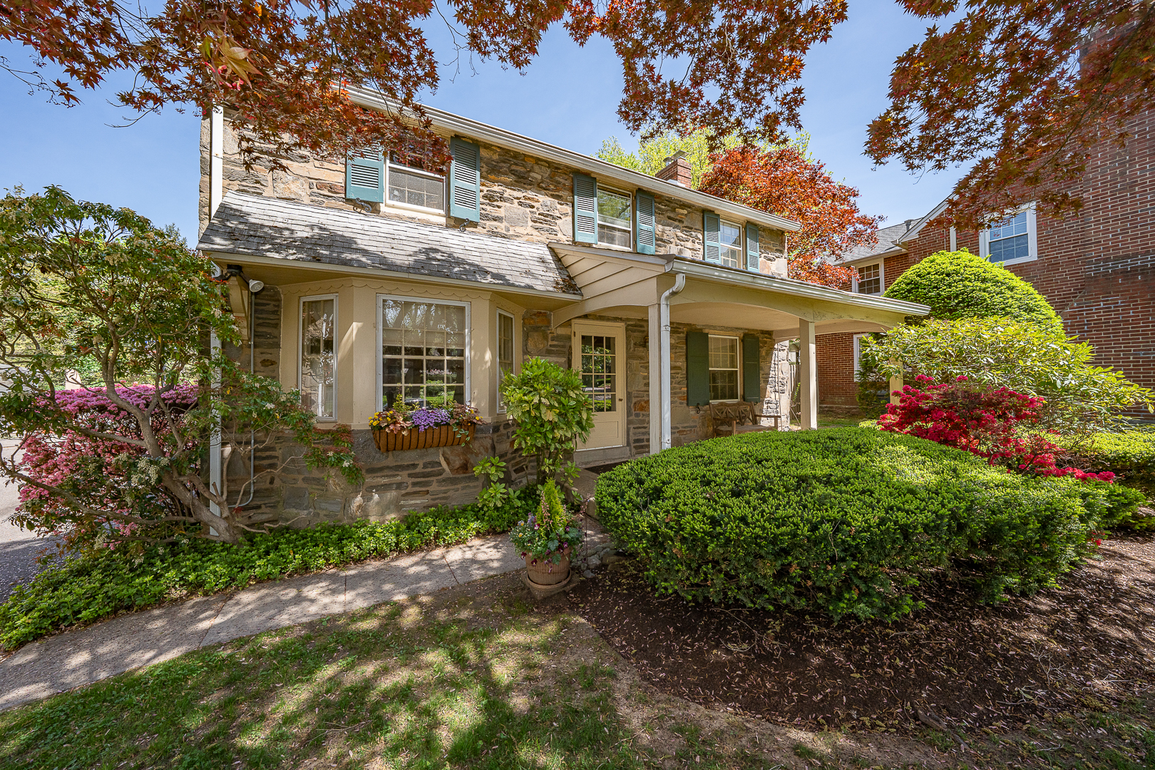 a view of a brick house with a yard and plants