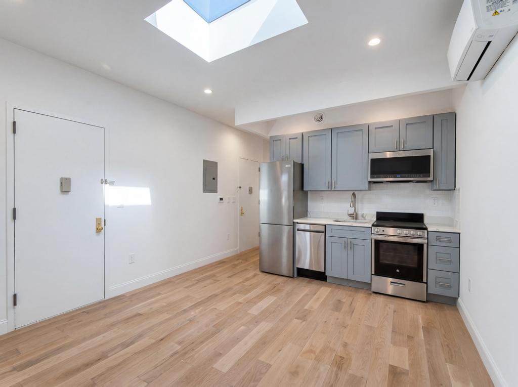 231 East 60th Street, Unit 5 Manhattan, NY 10022 - Photo 2 of 11 a kitchen with granite countertop a stove top oven a sink dishwasher and a refrigerator with wooden floor