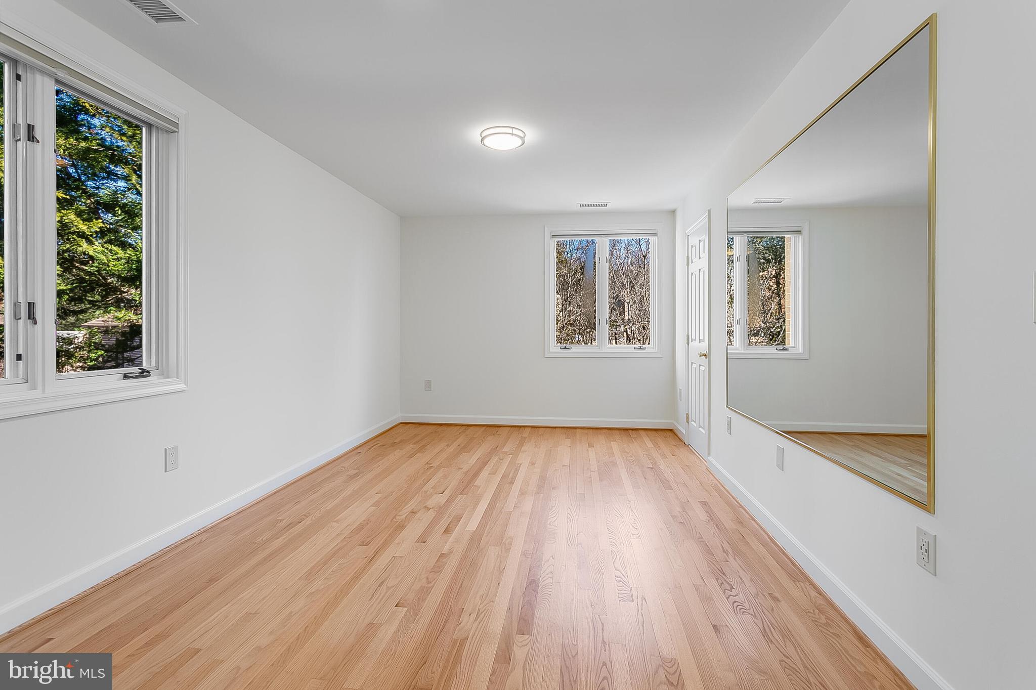 4709 Foxhall Crescent Northwest Washington, DC 20007 - Photo 46 of 57 an empty room with wooden floor and windows