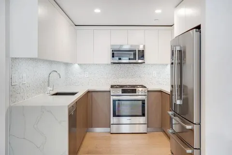 a kitchen with stainless steel appliances granite countertop a refrigerator sink and stove