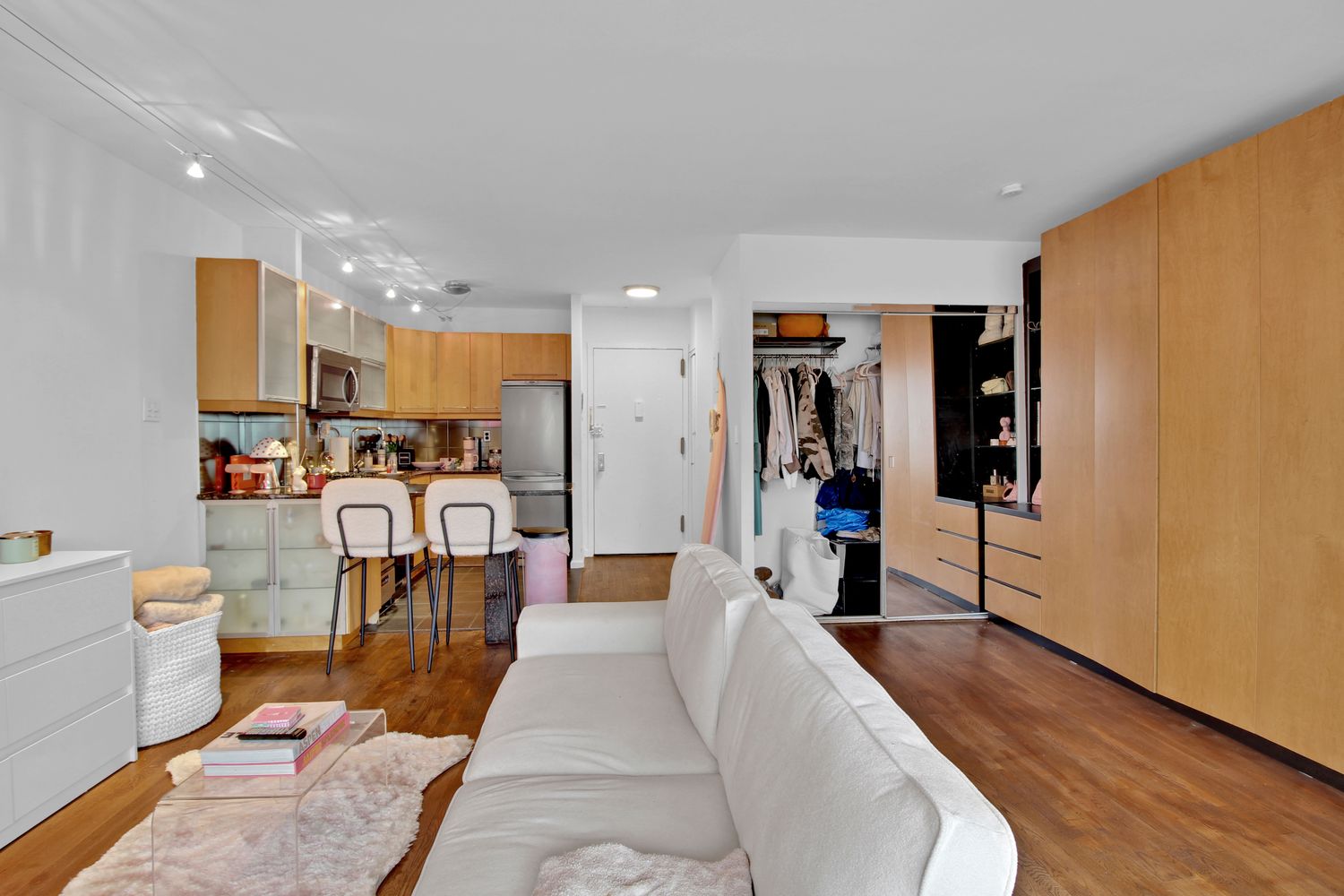 408 8th Avenue, Unit 8B Manhattan, NY 10001 - Photo 4 of 12 a living room with stainless steel appliances furniture a rug and a kitchen view
