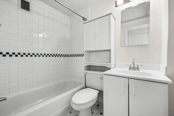 a bathroom with a sink toilet vanity and shower
