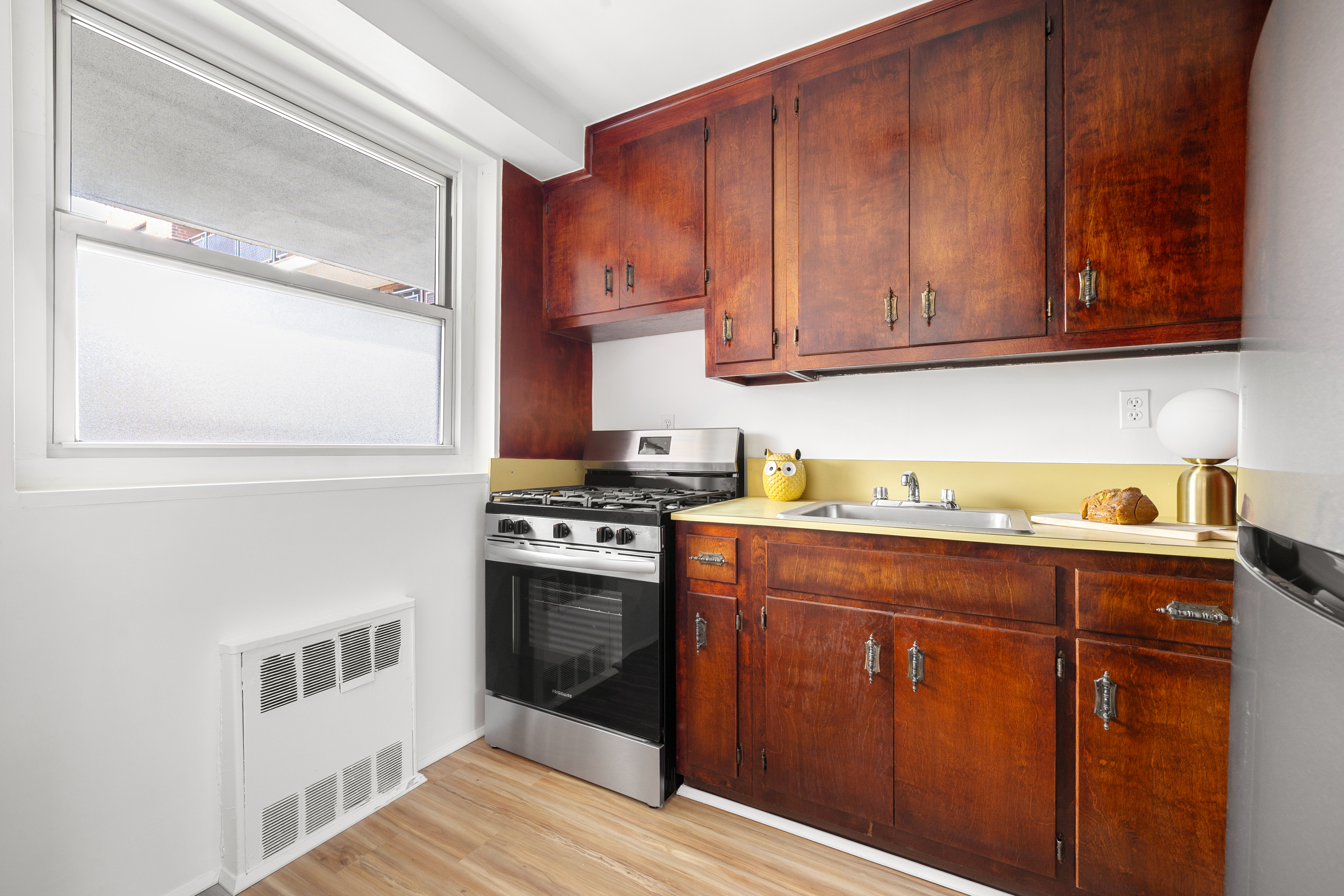 35-31 85th Street, Unit 6C Queens, NY 11372 - Photo 6 of 11 a kitchen with stainless steel appliances granite countertop a stove a sink and a microwave