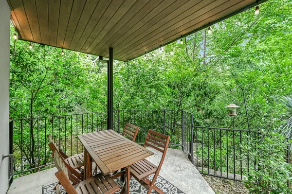 a view of a patio with table and chairs with wooden floor and fence
