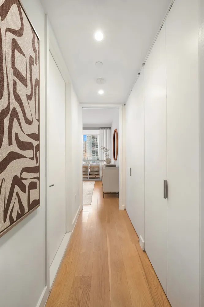 a view of a hallway with a dining table chairs