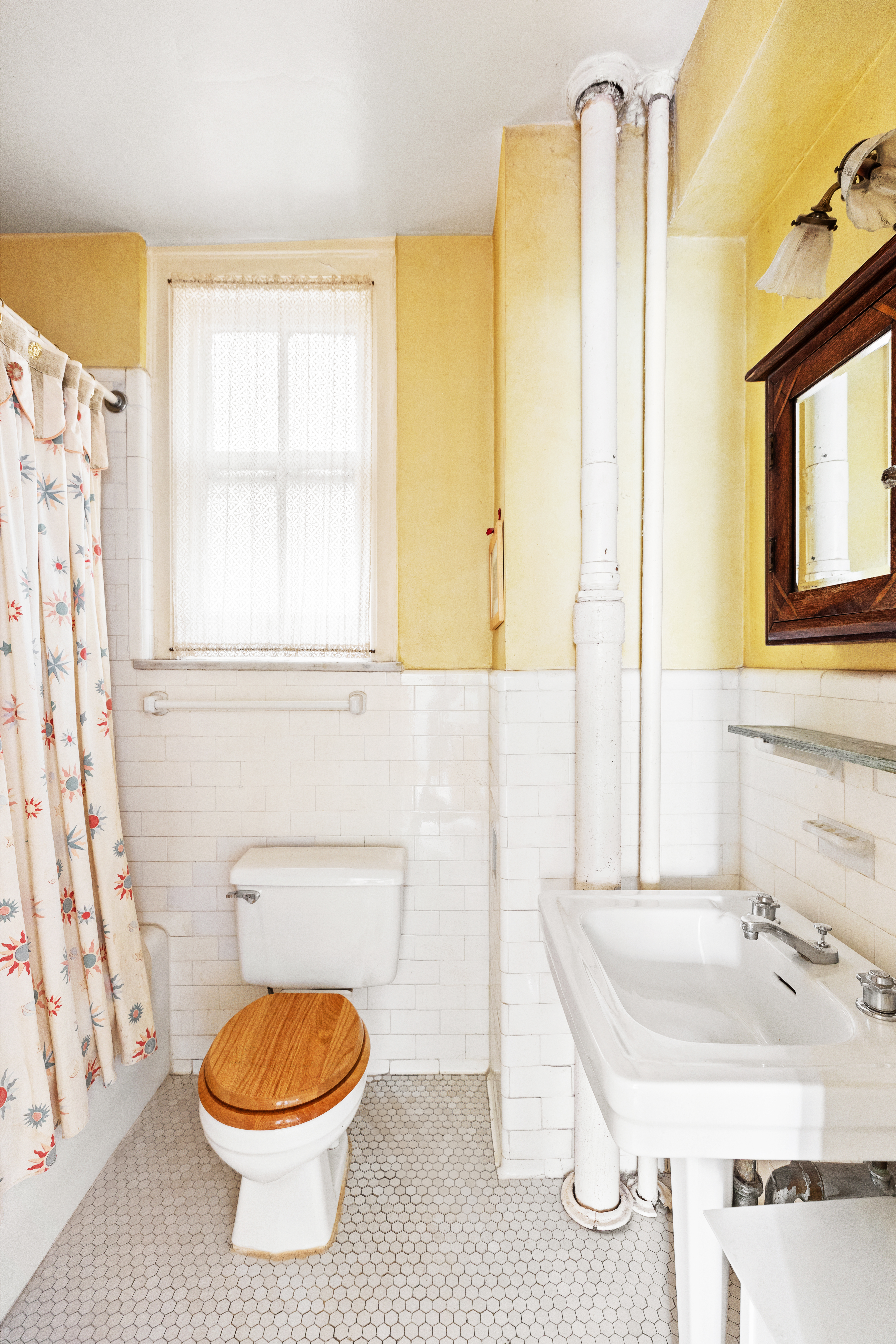 330 West 72nd Street, Unit 7A Manhattan, NY 10023 - Photo 8 of 10 a bathroom with a sink a toilet and shower curtain