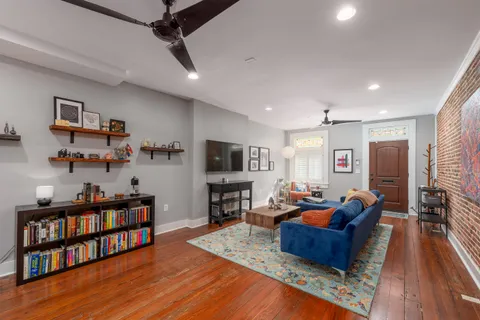 a living room with furniture hard wood floor and a flat screen tv