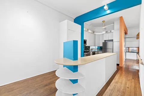 a kitchen with granite countertop white cabinets and wooden floor