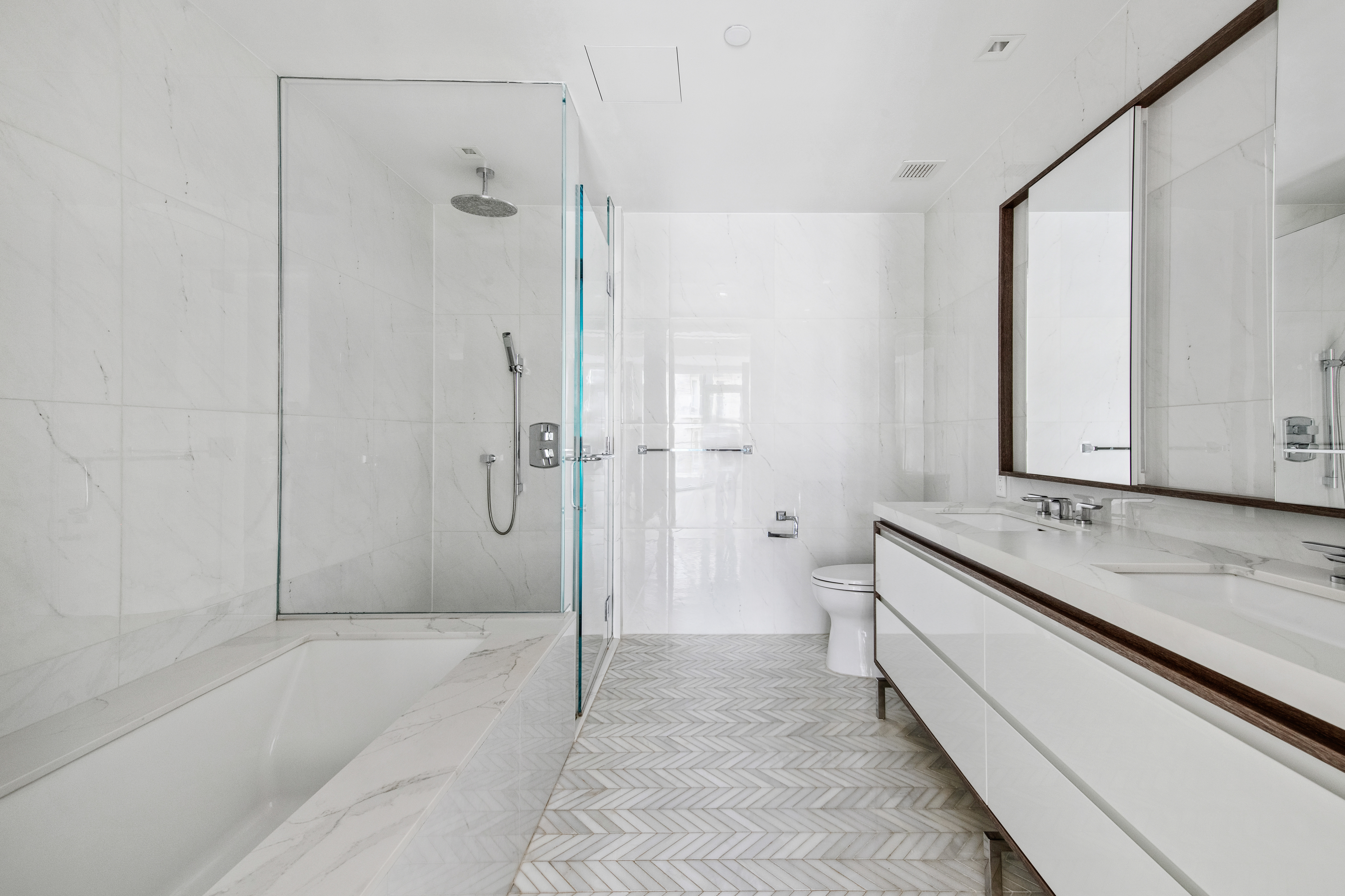 505-513 West 43rd Street, Unit 10B Manhattan, NY 10036 - Photo 11 of 22 a spacious bathroom with a granite countertop sink mirror and a bathtub
