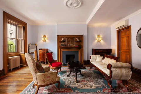 a living room with furniture a fireplace and a large window
