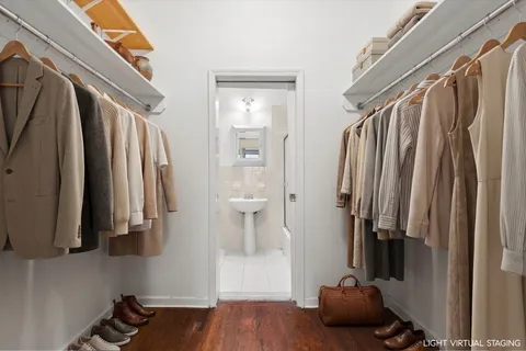 a view of walk in closet with clothes and shoes