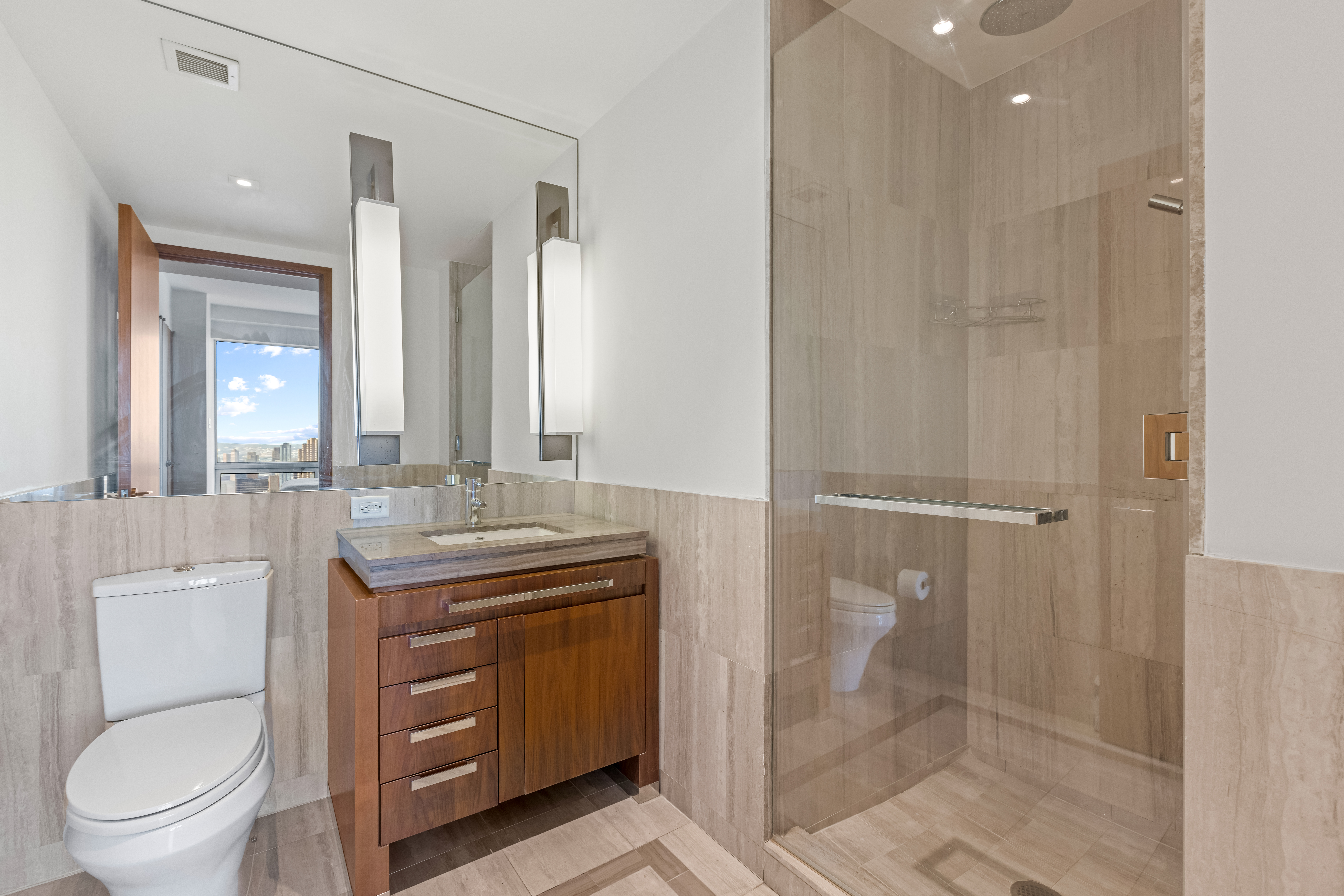 400 5th Avenue, Unit 49C Manhattan, NY 10018 - Photo 12 of 21 a bathroom with a granite countertop sink a toilet and shower