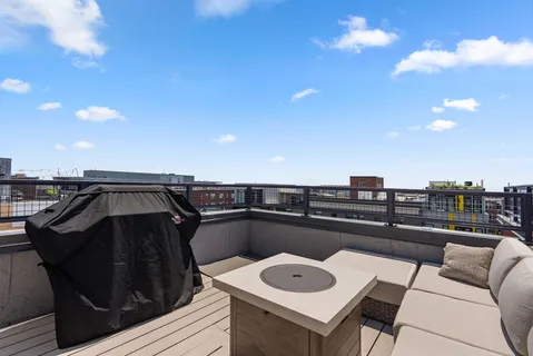 a view of a roof deck with couches and potted plants