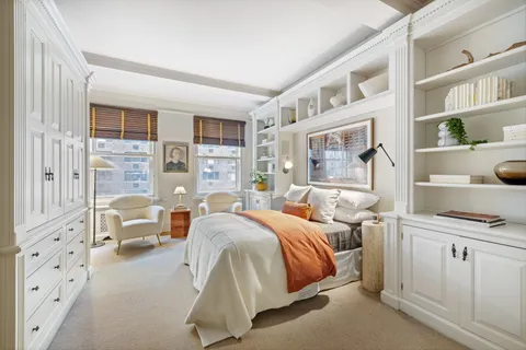 a bedroom with a bed next to a large window