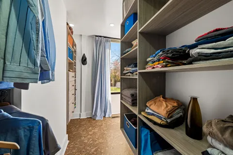 a view of walk in closet with clothes and shoes