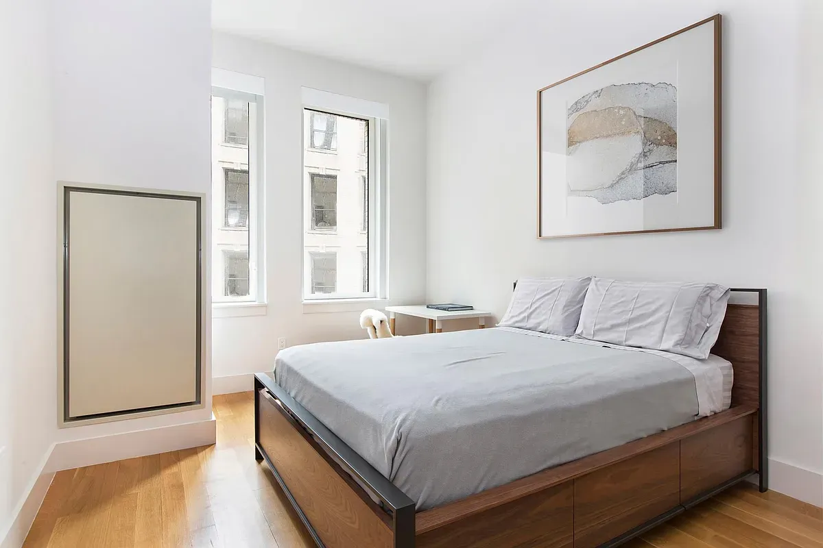 a bedroom with a bed and a painting on the wall