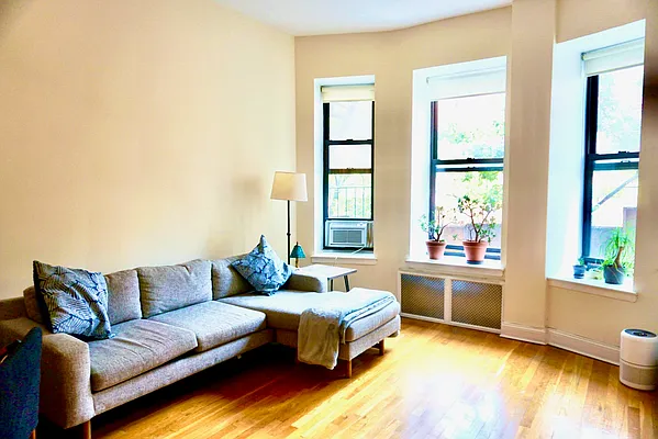 30 East 95th Street, Unit 2E Manhattan, NY 10128 - Photo 2 of 6 a living room with furniture and a large window