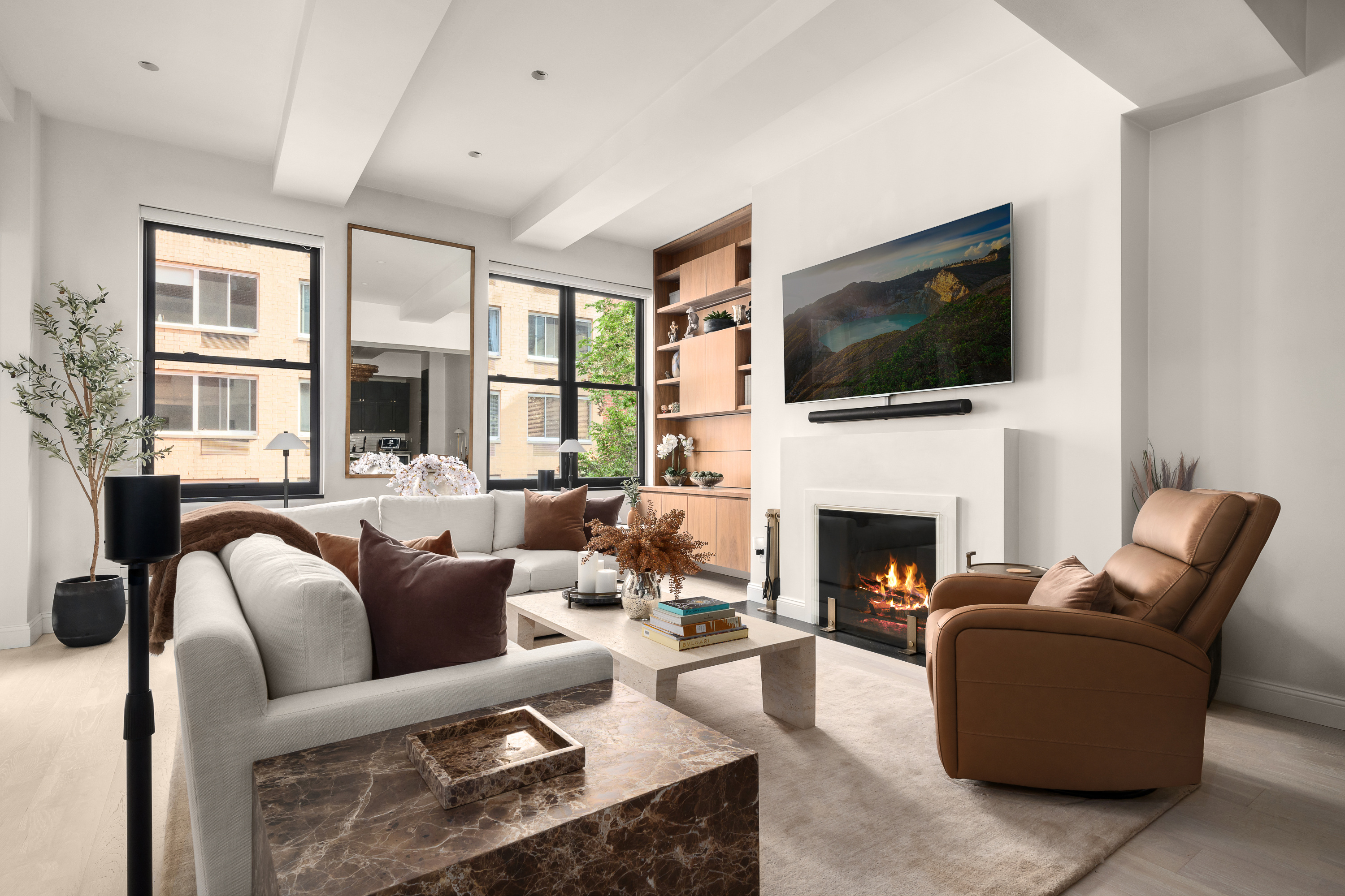 521 West 47th Street, Unit 3B Manhattan, NY 10036 - Photo 5 of 15 a living room with furniture a flat screen tv and a fireplace