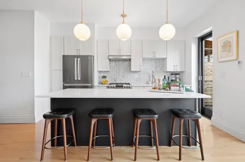 a kitchen with stainless steel appliances kitchen island a table and chair in it