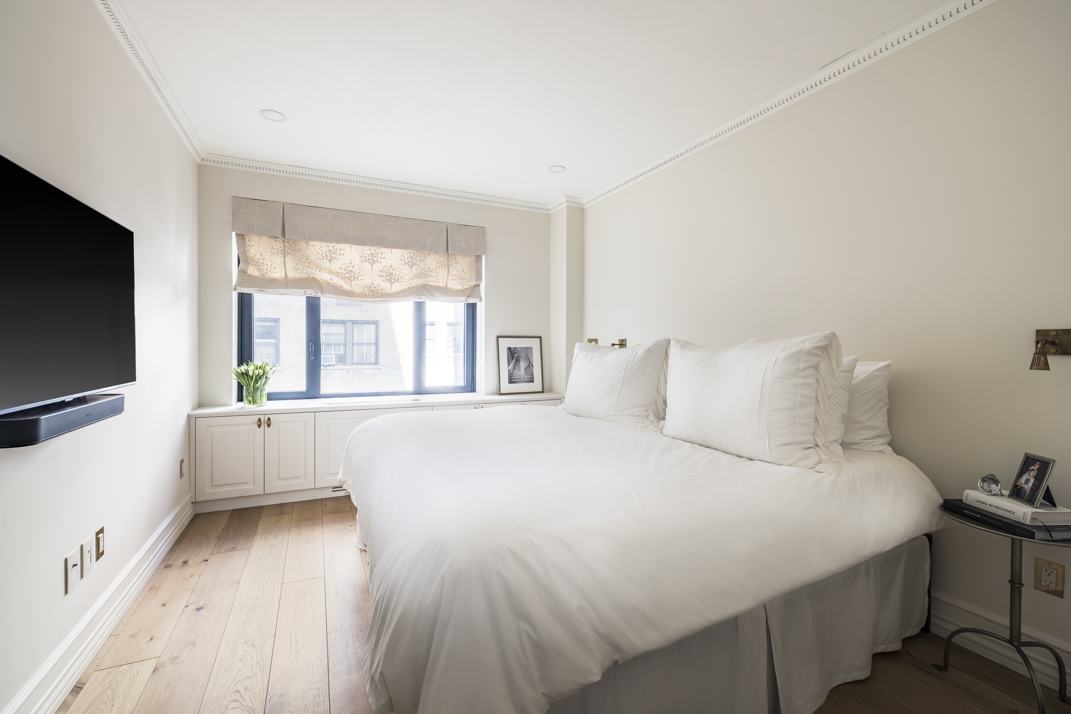 47 East 87th Street, Unit 7A Manhattan, NY 10128 - Photo 10 of 22 a bedroom with a large bed and a flat tv screen on dresser