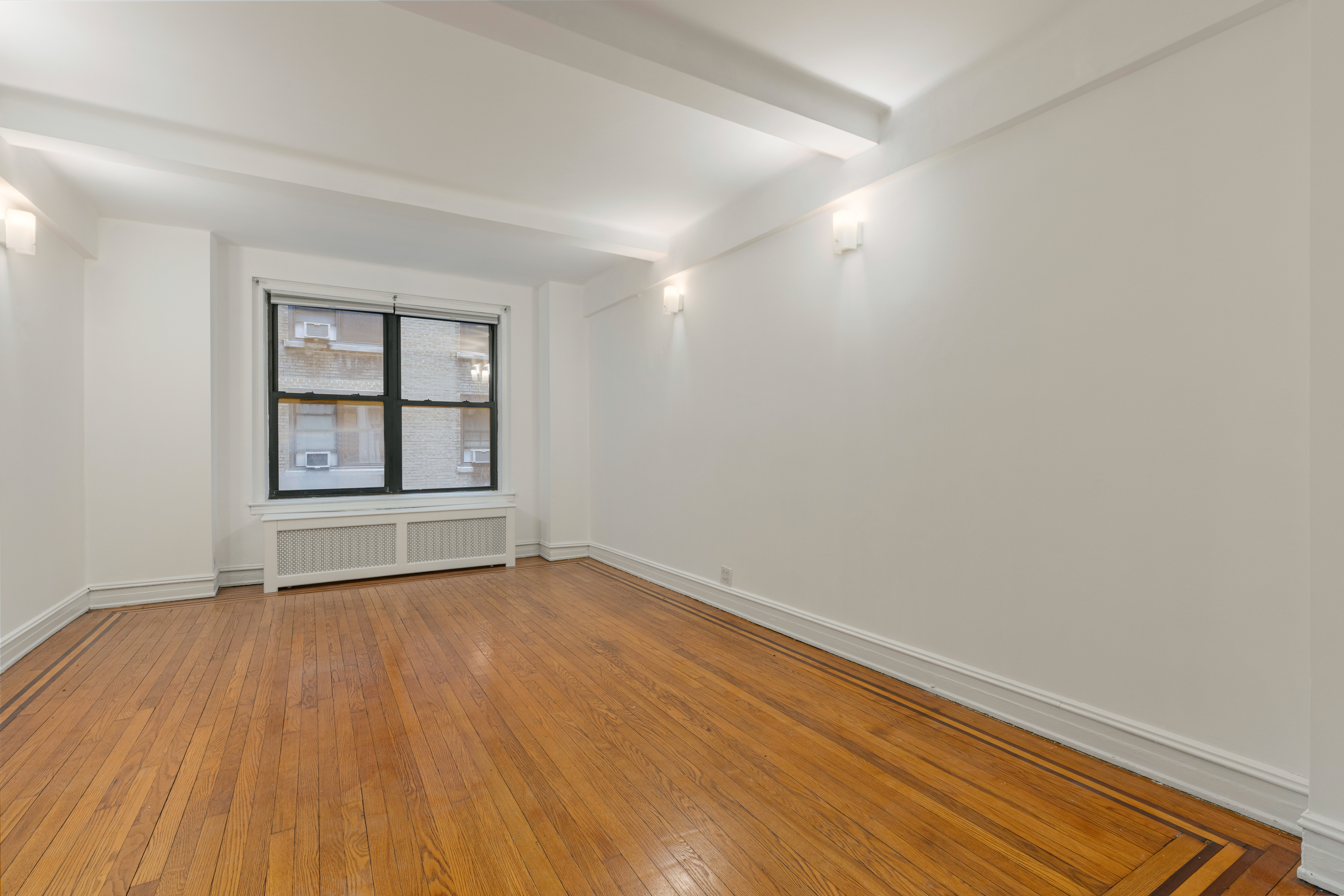 235 West 102nd Street, Unit 4E Manhattan, NY 10025 - Photo 6 of 19 wooden floor in an empty room with a window