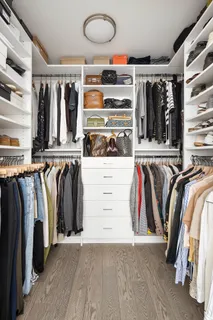 a view of walk in closet with clothes and shoes