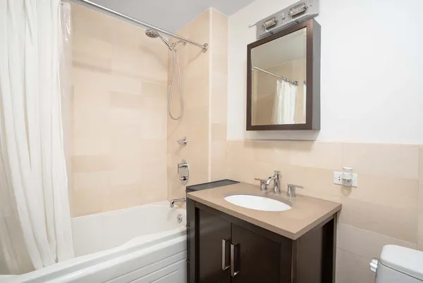 a bathroom with a bath tub sink mirror and a shower