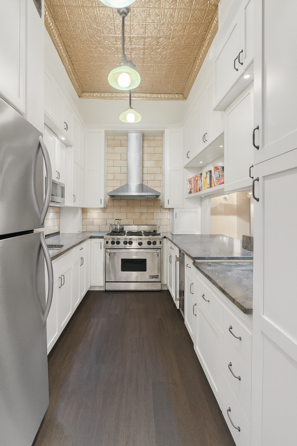 228 West 21st Street, Unit 4 Manhattan, NY 10011 - Photo 5 of 14 a kitchen with granite countertop white cabinets and white appliances