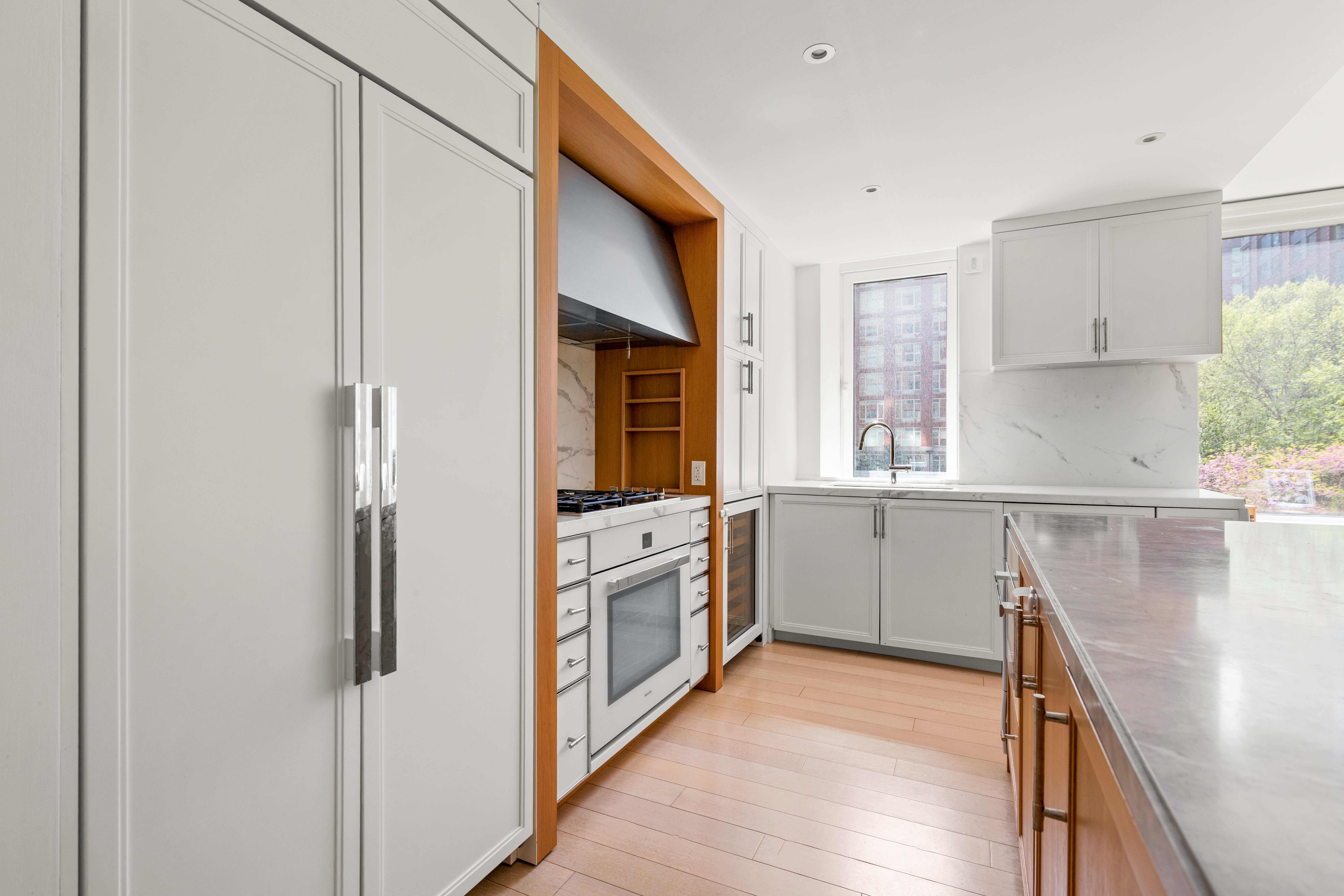 212 Warren Street, Unit 3B Manhattan, NY 10282 - Photo 3 of 11 a kitchen with white cabinets and white appliances