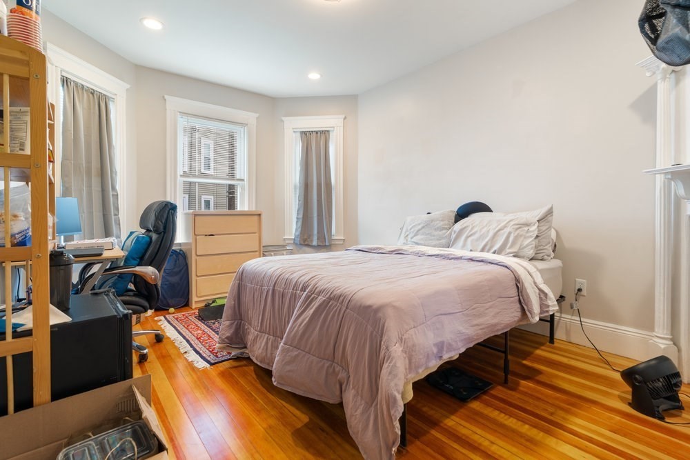 24 Buttonwood Street Boston, MA 02125 - Photo 25 of 43 a bedroom with a bed and wooden floor