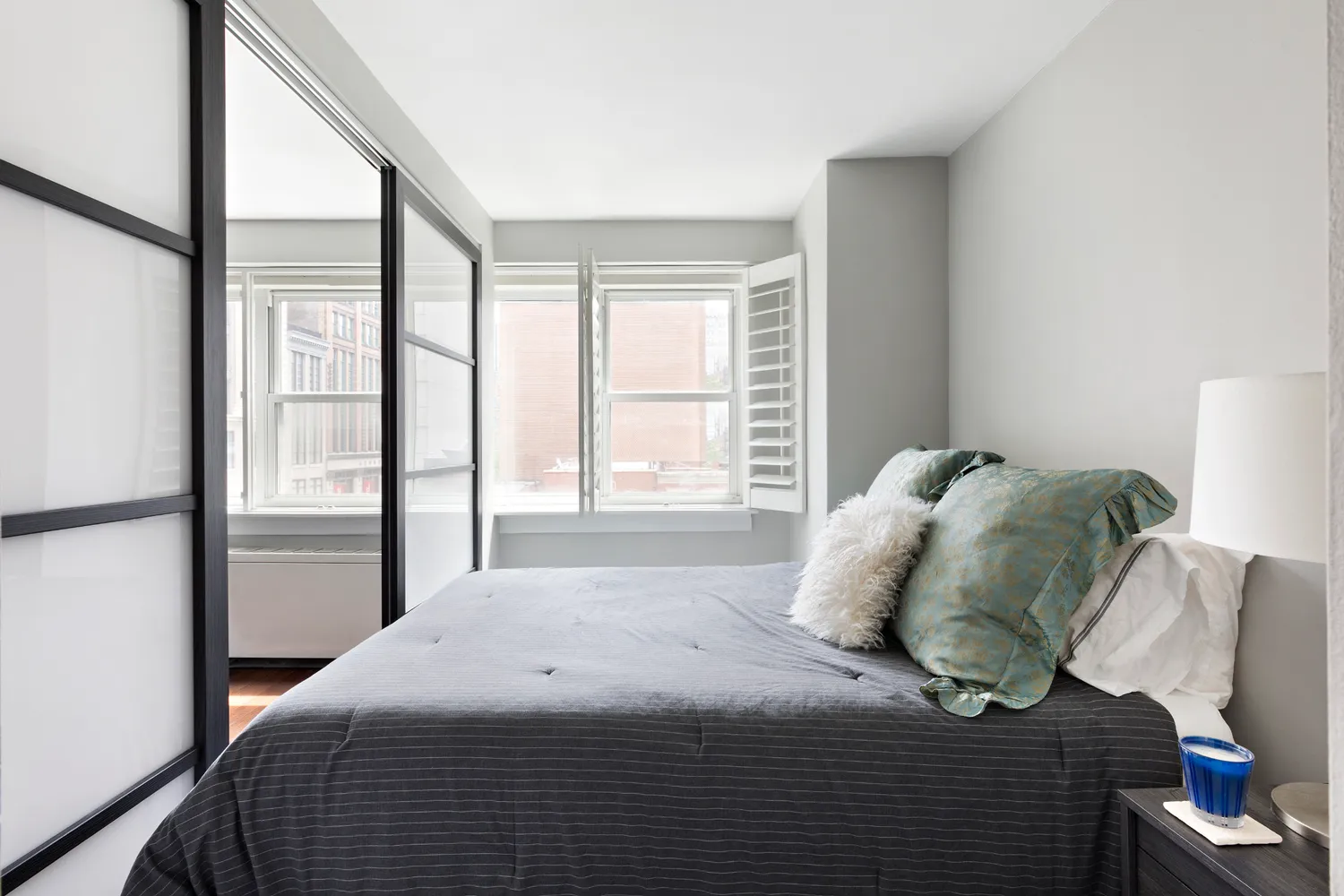 a bedroom with a bed and a large window