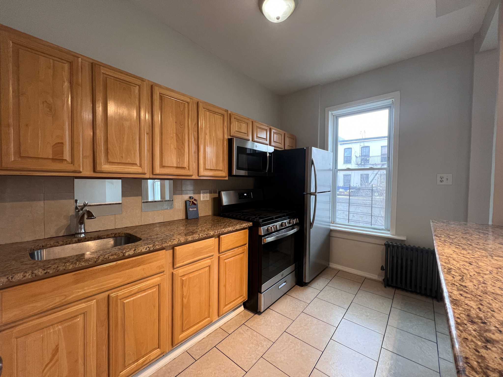 236 45th Street, Unit 2 Brooklyn, NY 11220 - Photo 2 of 8 a kitchen with granite countertop a sink a stove top oven and cabinets
