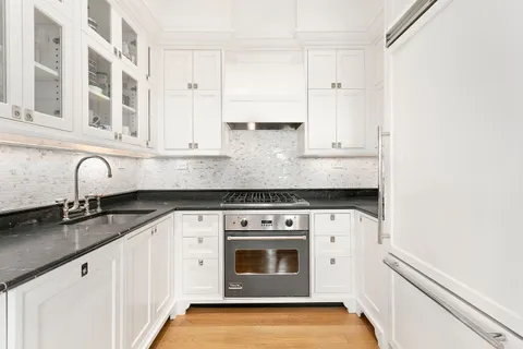 a kitchen with granite countertop white cabinets and white appliances