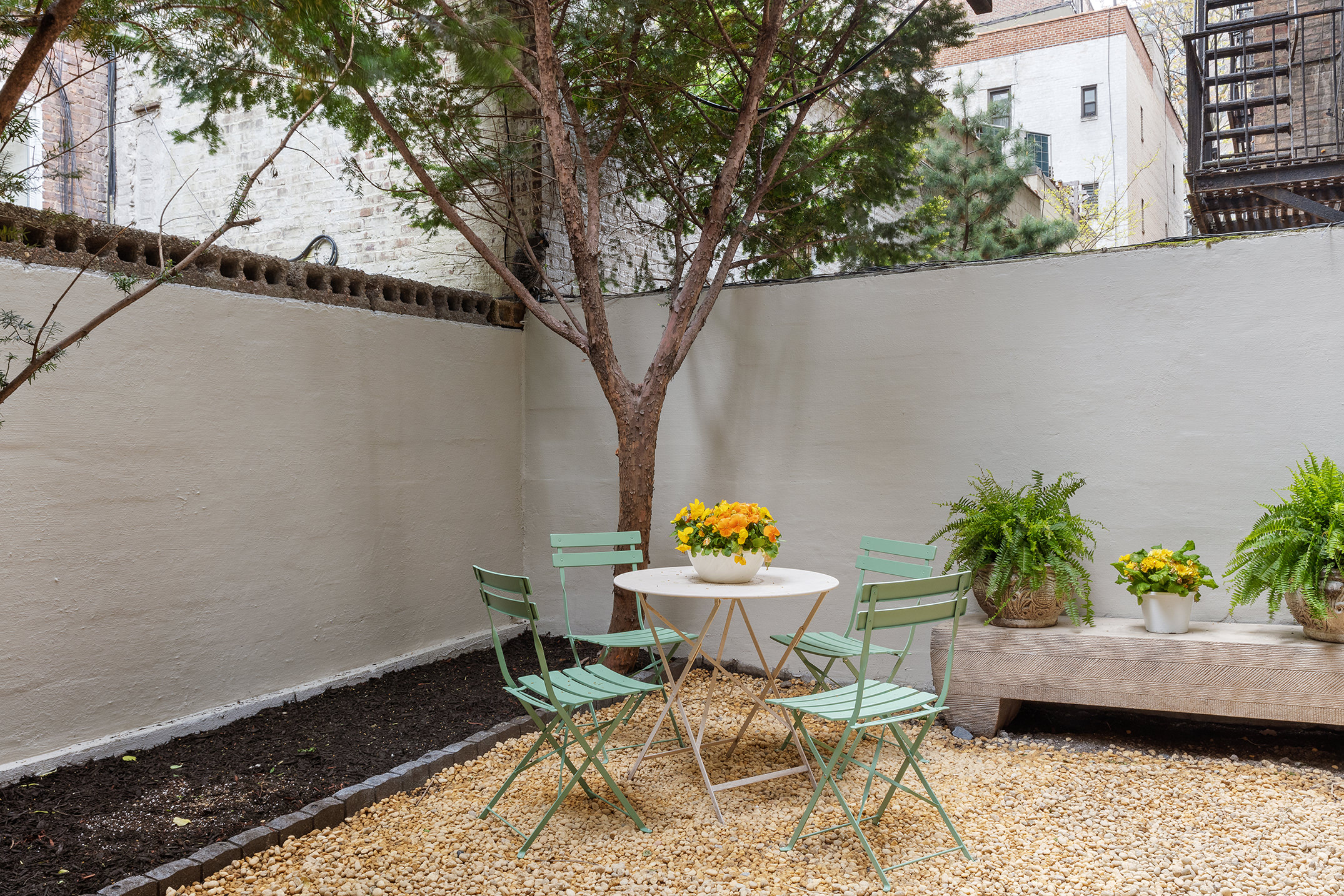 71 East 3rd Street, Unit 4 Manhattan, NY 10003 - Photo 12 of 18 a backyard of a house with table and chairs