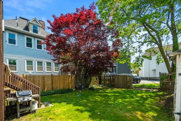 a view of a house with backyard and a tree