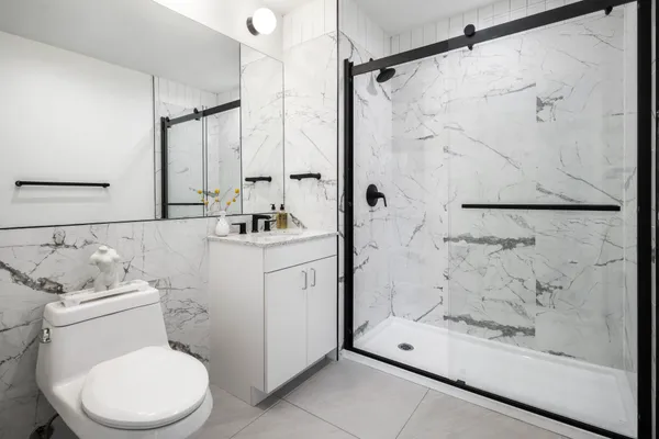 a bathroom with a sink a toilet and shower