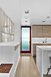 a kitchen with stainless steel appliances a sink a stove a refrigerator cabinets and living room view